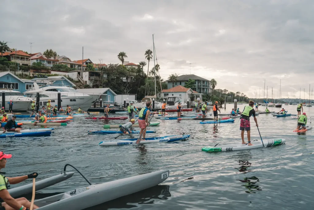 Wide view of paddleboarders and kayakers before the Bay to Beach race