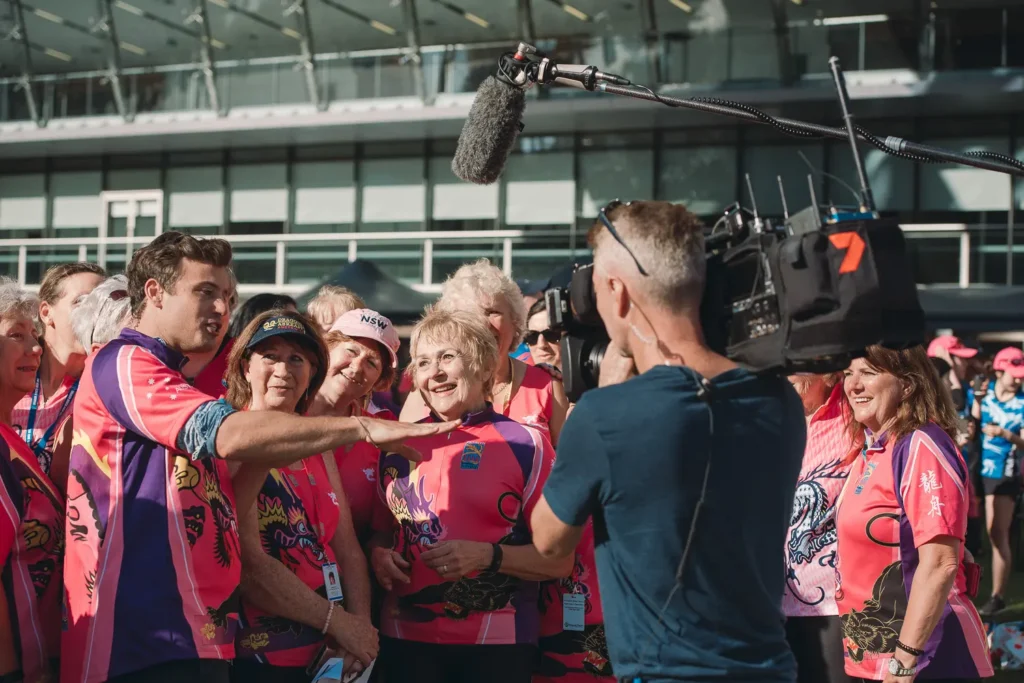 Television crew interviewing dragon boat participants during Sydney festival