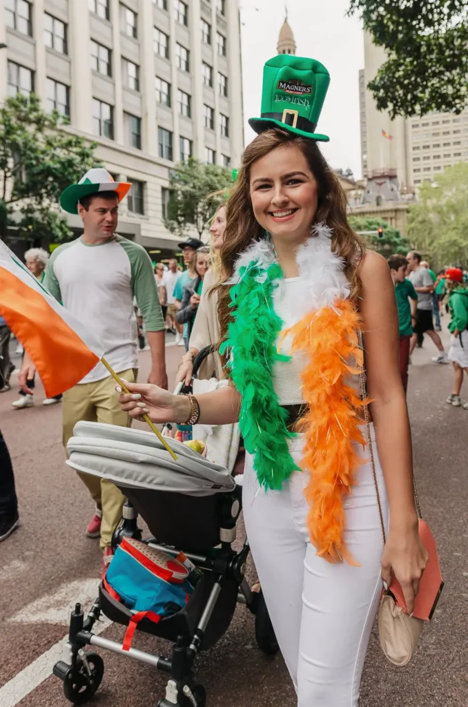 Woman wearing Irish themed outfit holding Irish flag at Sydney celebration