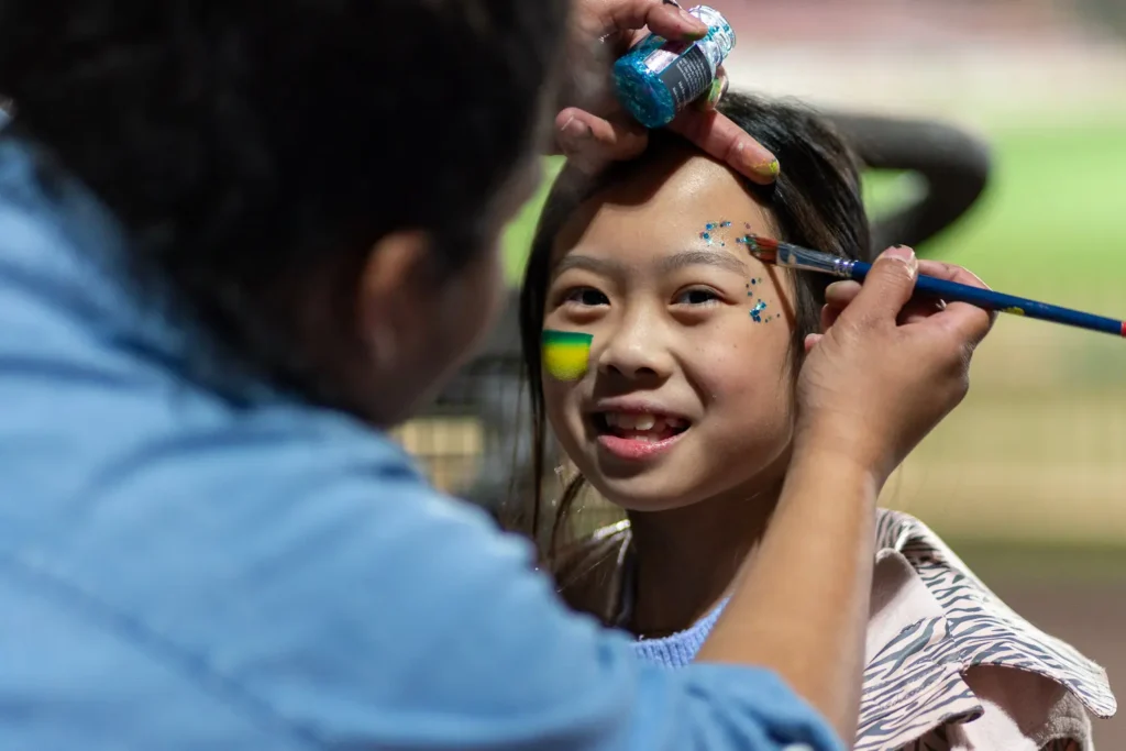 Child smiling during face painting before the Matildas screening in Sydney