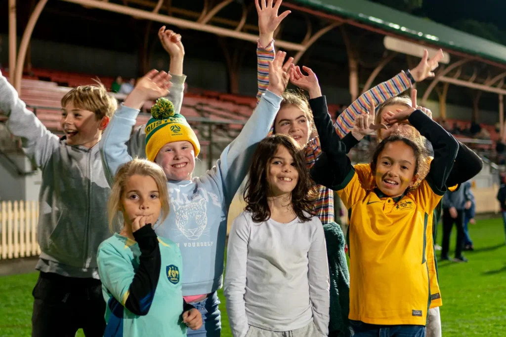 Young Matildas supporters cheering together at North Sydney Oval live site