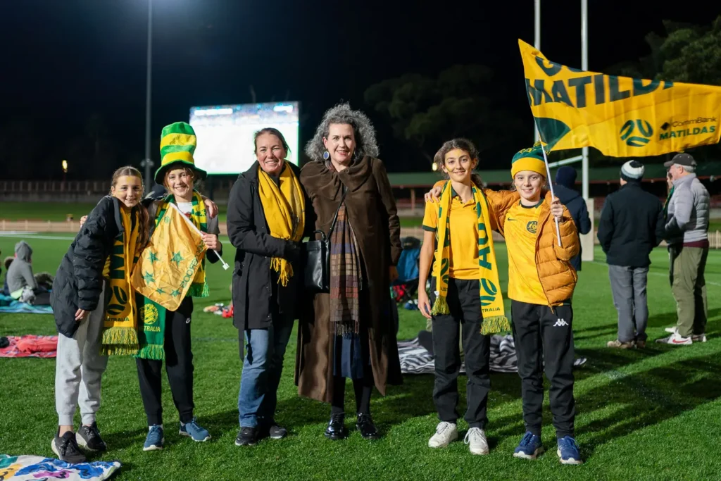 Matildas fans posing for a group photo with Therese Cole and Zoe Baker from North Sydney Council at North Sydney Oval live site