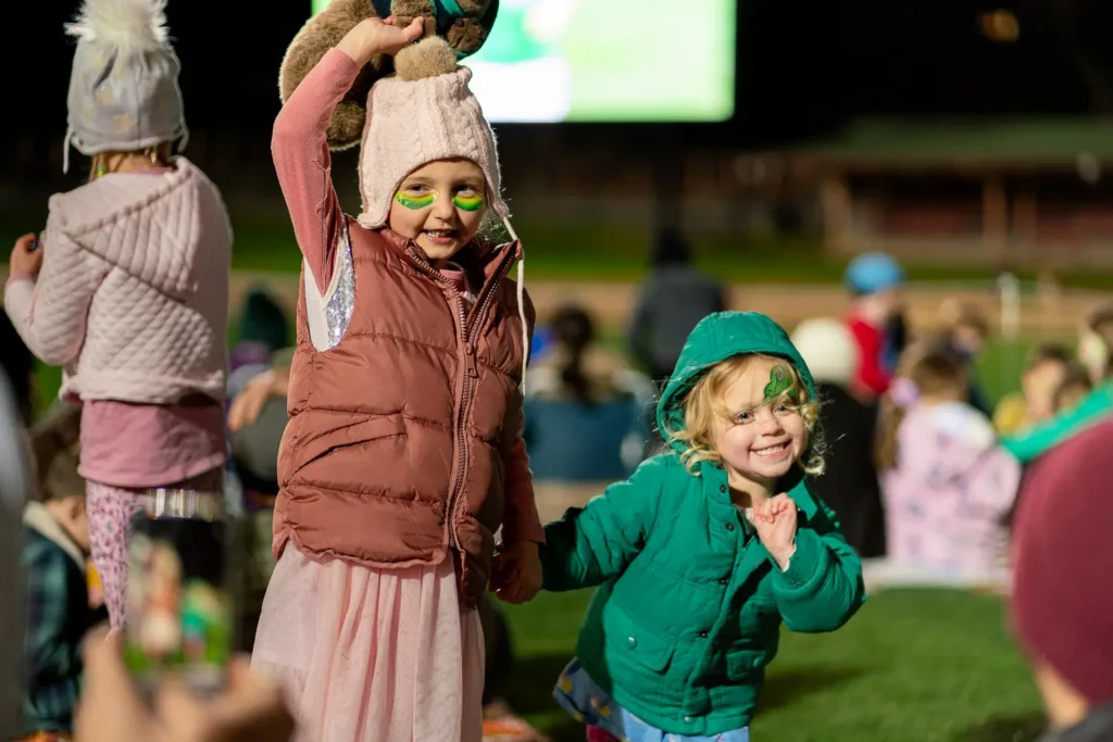 Young Matildas supporters smiling and waving at North Sydney Oval live site