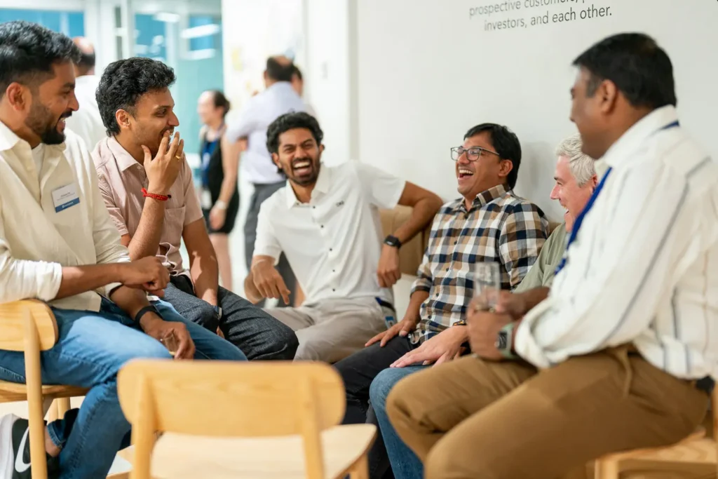 Group of colleagues sharing a laugh during a relaxed corporate office event