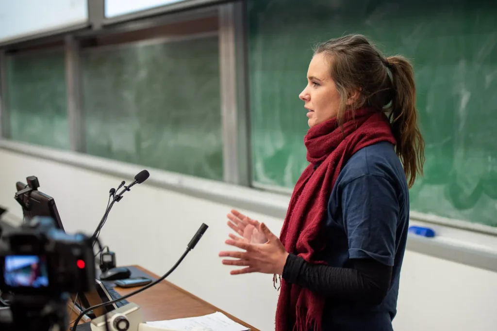 Female conference speaker presenting at a lectern in a university lecture theatre