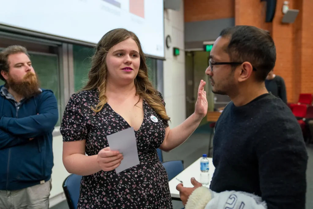 Female conference speaker talking with an attendee after her presentation