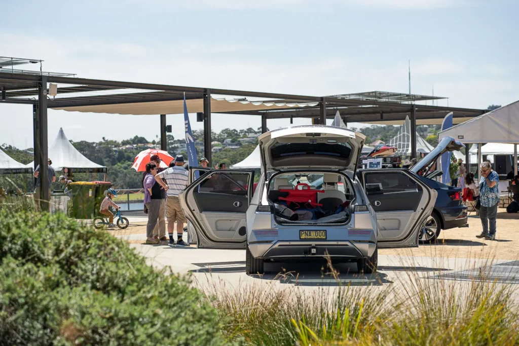 Visitors exploring an electric car at a sustainability event in Sydney