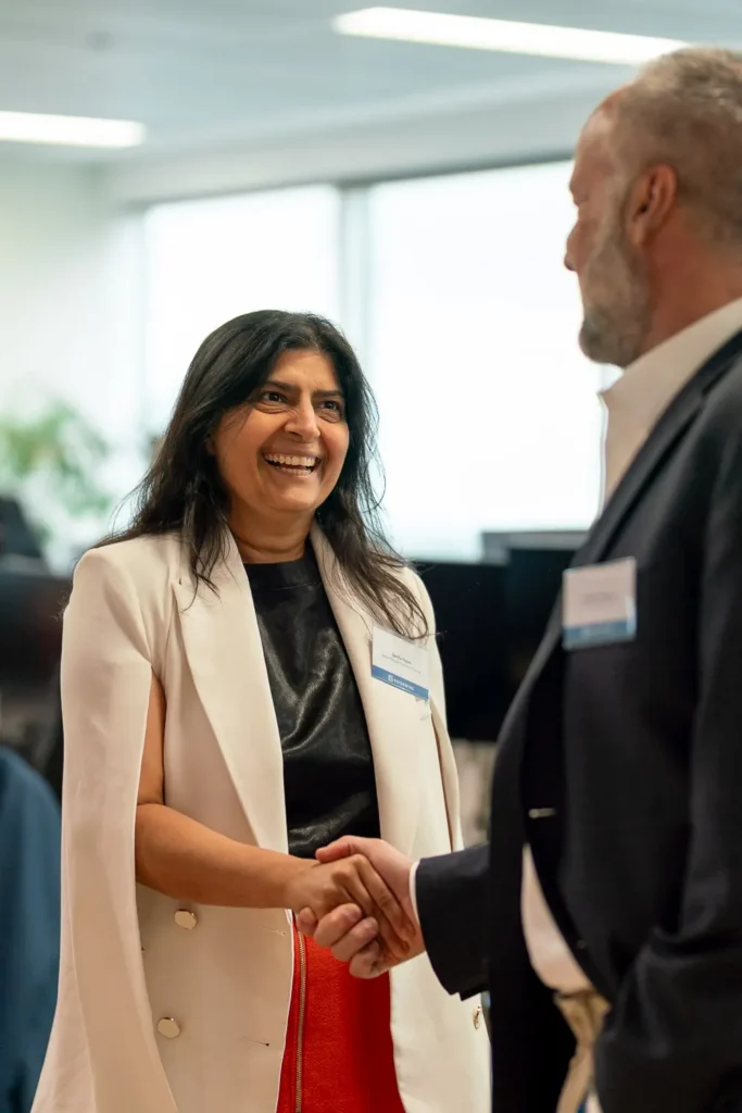 Guest greeting a colleague at the Guidewire Sydney office opening event