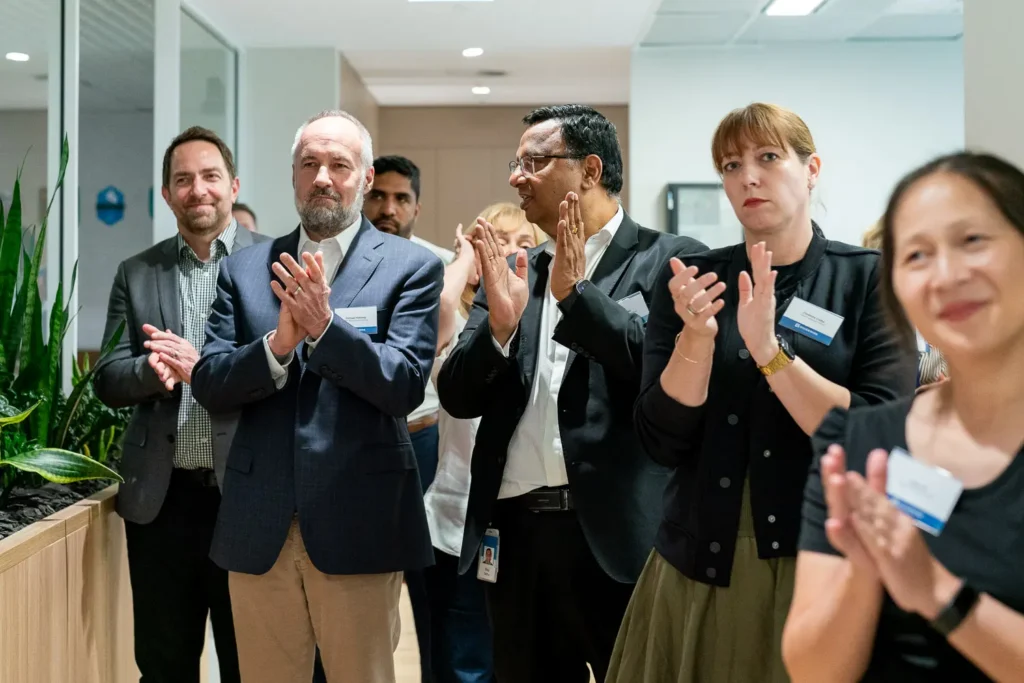 Guidewire executives and guests applauding during the Sydney office opening