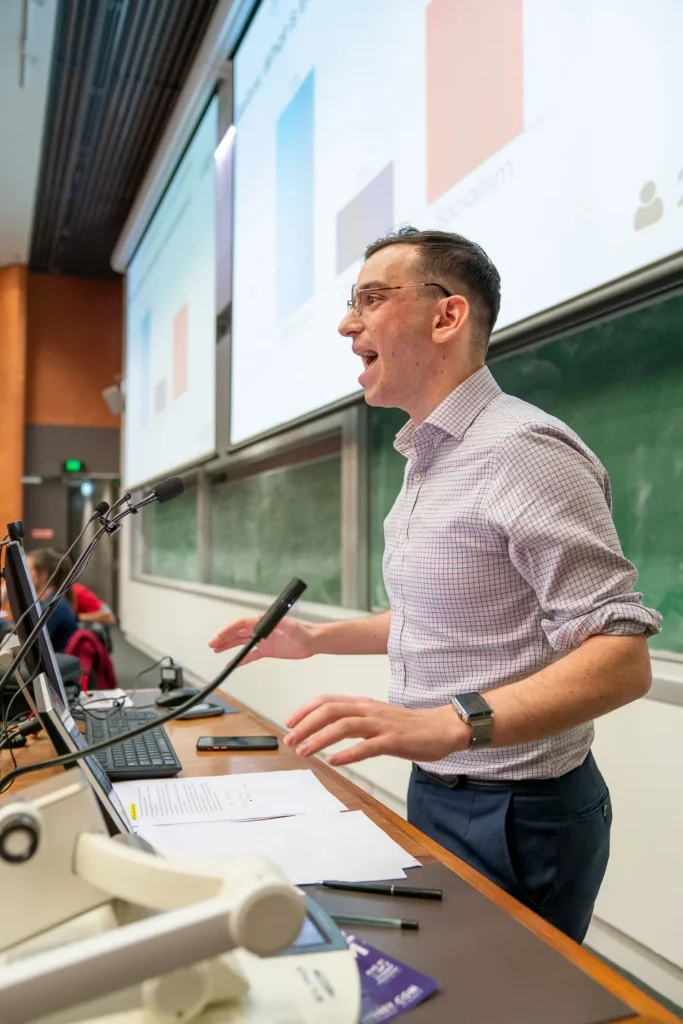 Male speaker giving an animated presentation at a conference