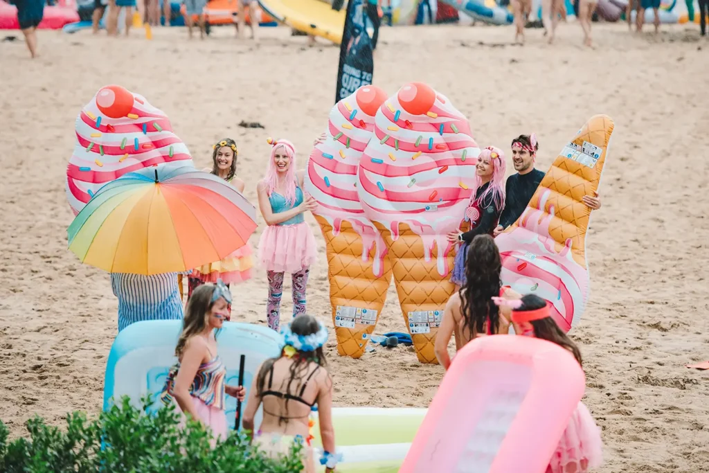 Participants with colourful ice cream inflatables at the Manly Inflatable Boat Race at Shelly Beach