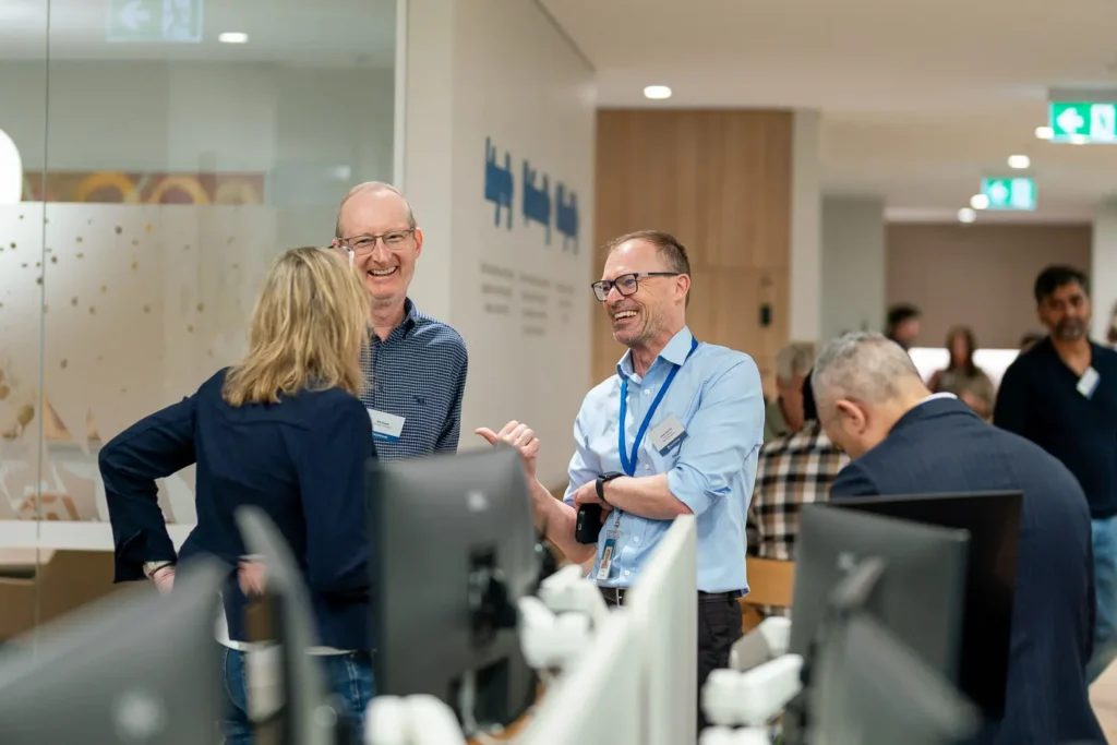 Professionals chatting and laughing during a relaxed office networking event