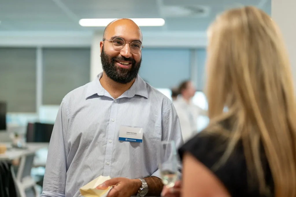 Professionals having a friendly conversation at an office networking function