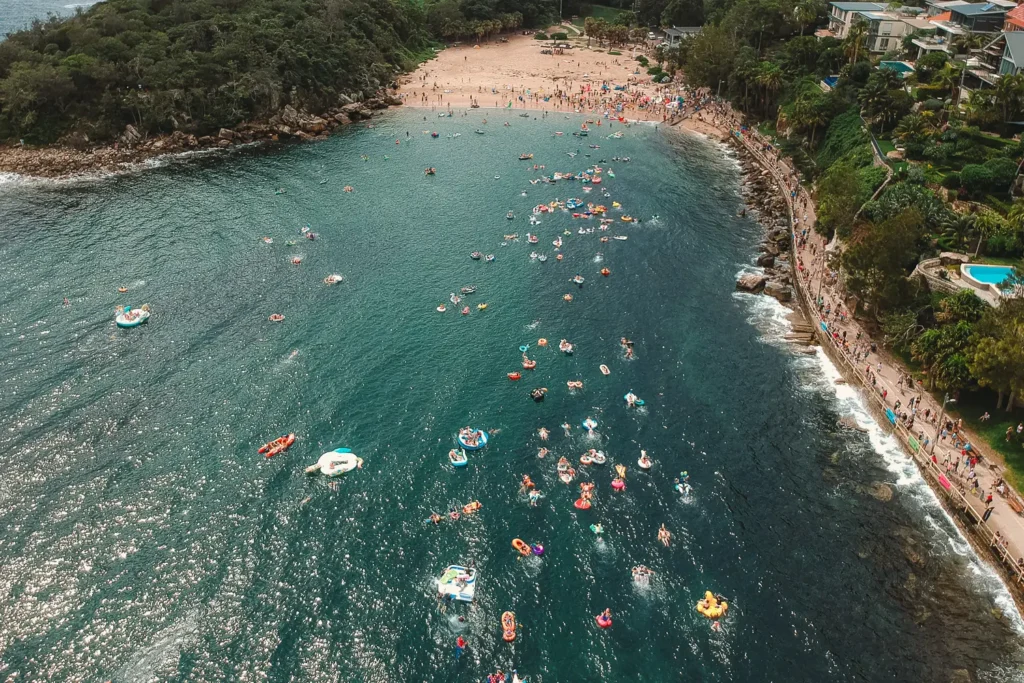 Wide aerial view of Shelly Beach and participants in the Manly Inflatable Boat Race