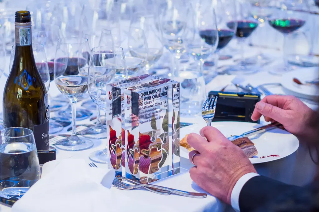 Six Nations Wine Challenge awards displayed among wine glasses at the dinner table