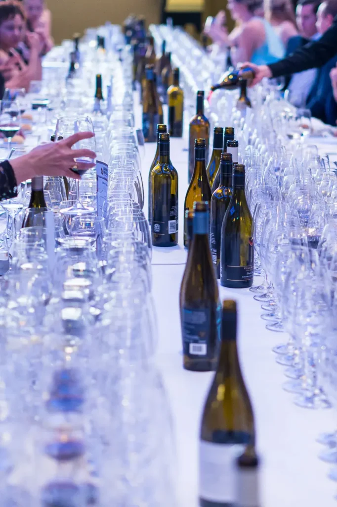 Long wine tasting table filled with bottles and glasses at the Six Nations Wine Challenge