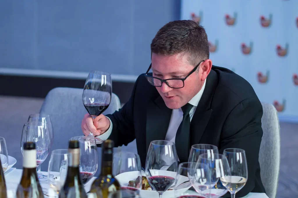 Guest assessing a glass of red wine during the Six Nations Wine Challenge