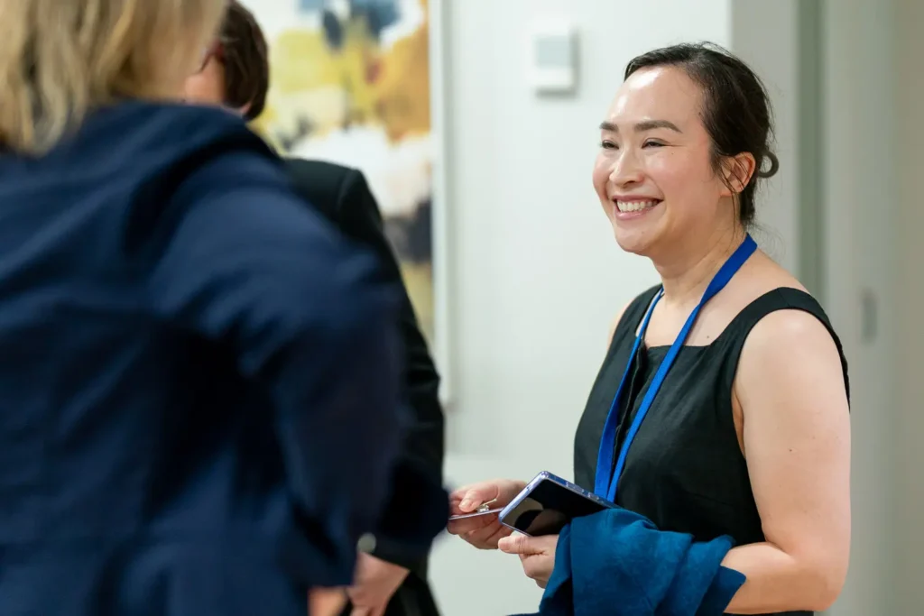 Smiling guest chatting with colleagues during a corporate networking event