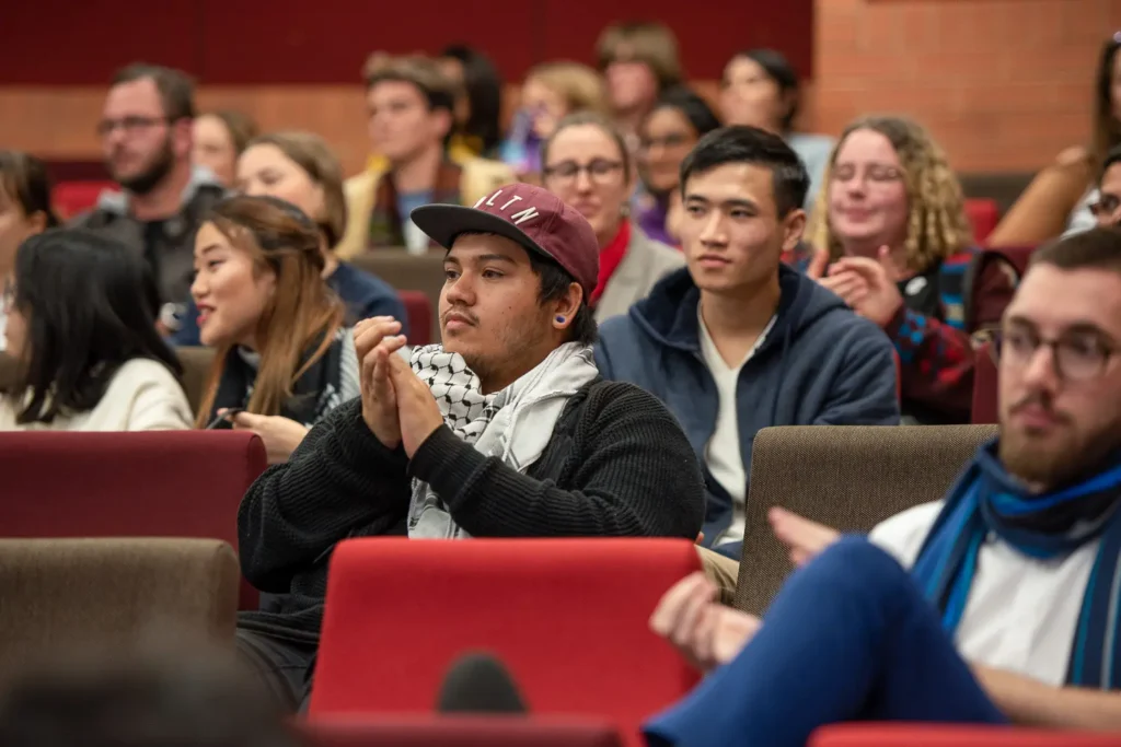 Students applauding during the Socialism vs Capitalism debate at the University of Sydney