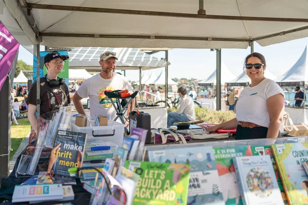 Community sustainability stall with books and educational resources at an outdoor festival