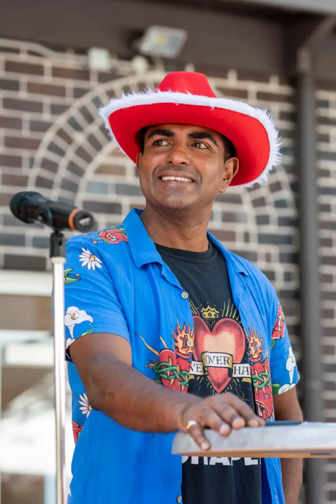 Speaker in a festive red hat at the Wayside Chapel Christmas Day event in Sydney