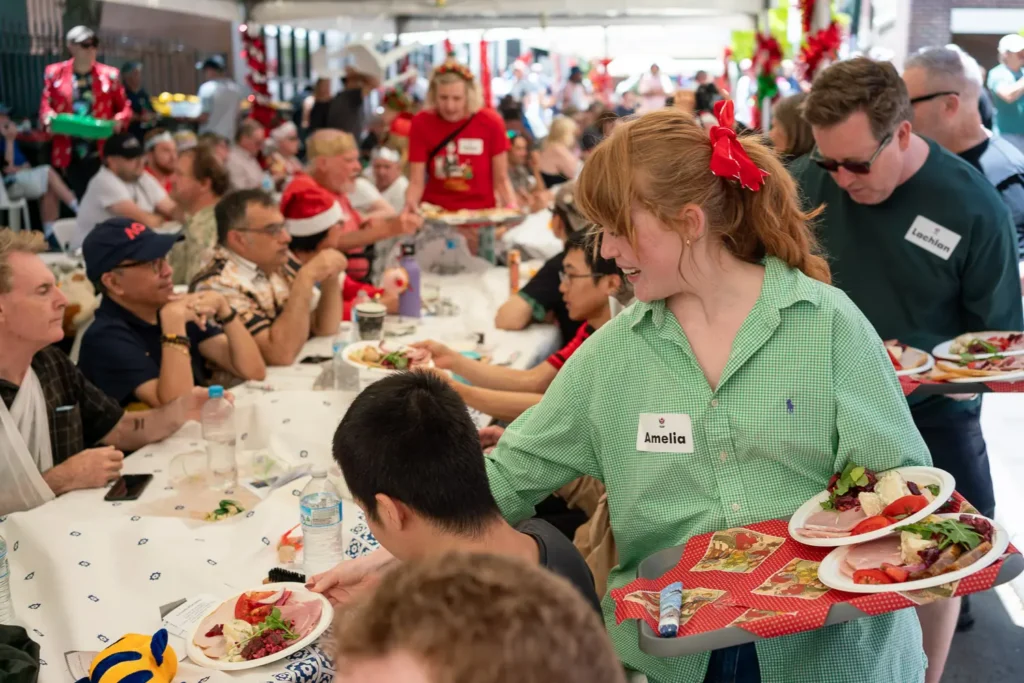 Volunteer serving plates of food to guests during the Wayside Chapel Christmas lunch
