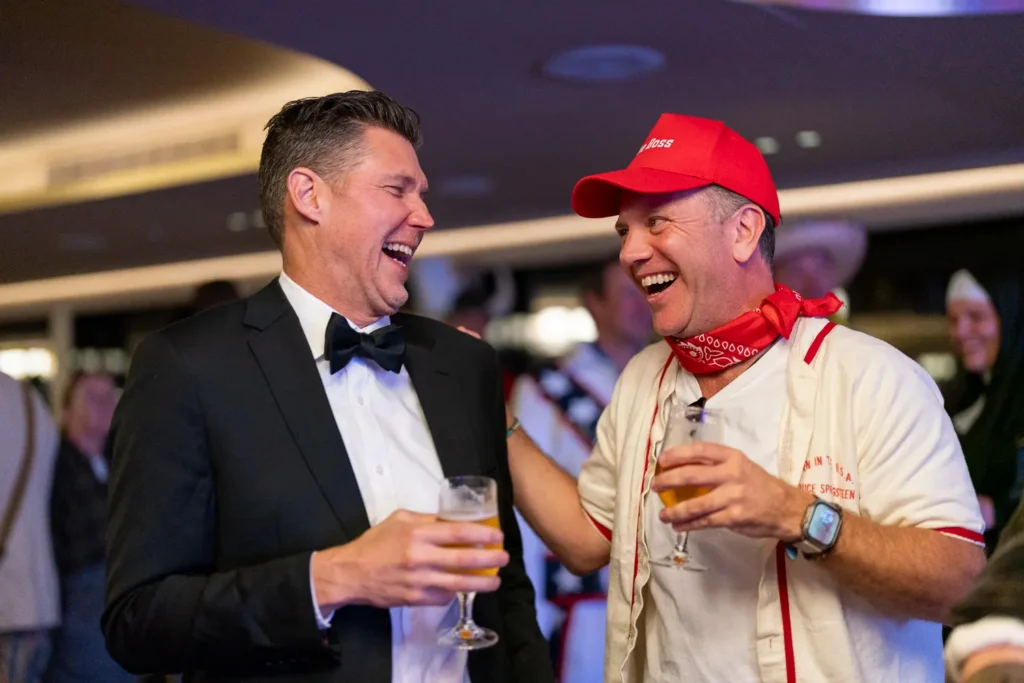 Two guests laughing together in costume during a corporate event in Sydney