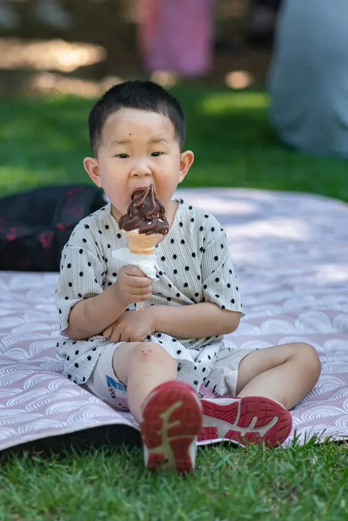 Event photography in North Sydney capturing a child enjoying ice cream at the St Leonards Park playground opening