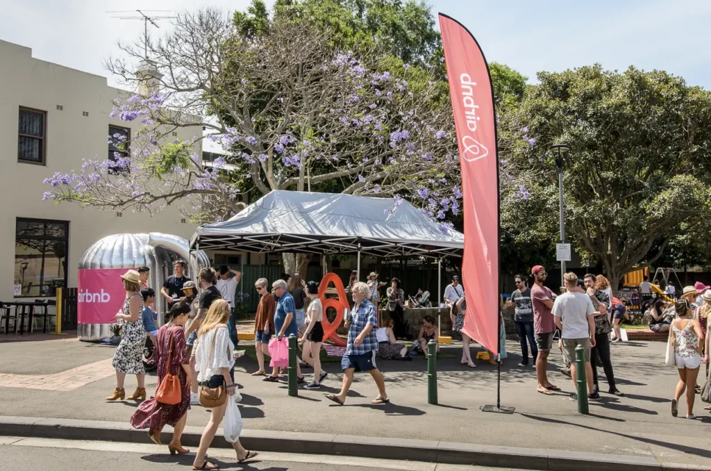 Airbnb promotional activation with branded displays and festival visitors at Glebe Street Fair Sydney