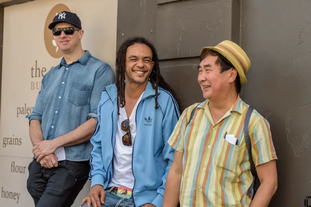 Three festival visitors sharing a relaxed and cheerful moment at Glebe Street Fair Sydney