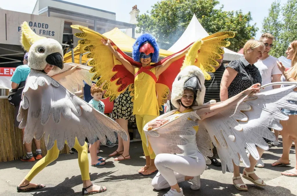 Colourful bird-costumed street performers entertaining visitors at Glebe Street Fair Sydney