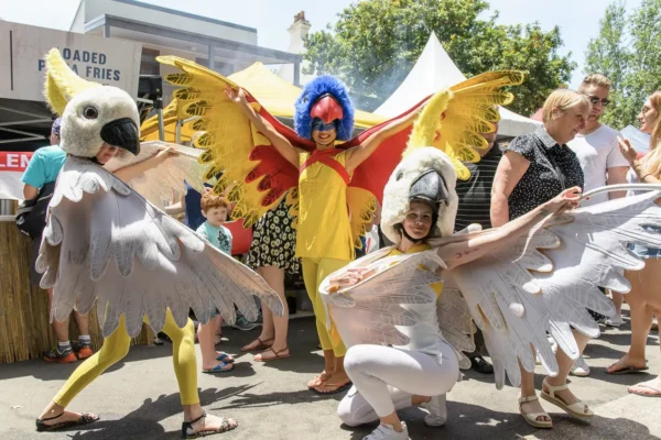 Colourful bird-costumed street performers entertaining visitors at Glebe Street Fair Sydney