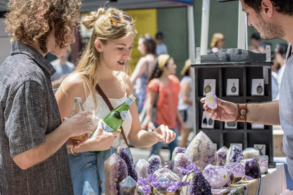 Festival visitors exploring amethyst crystals and gemstones at a Glebe Street Fair market stall