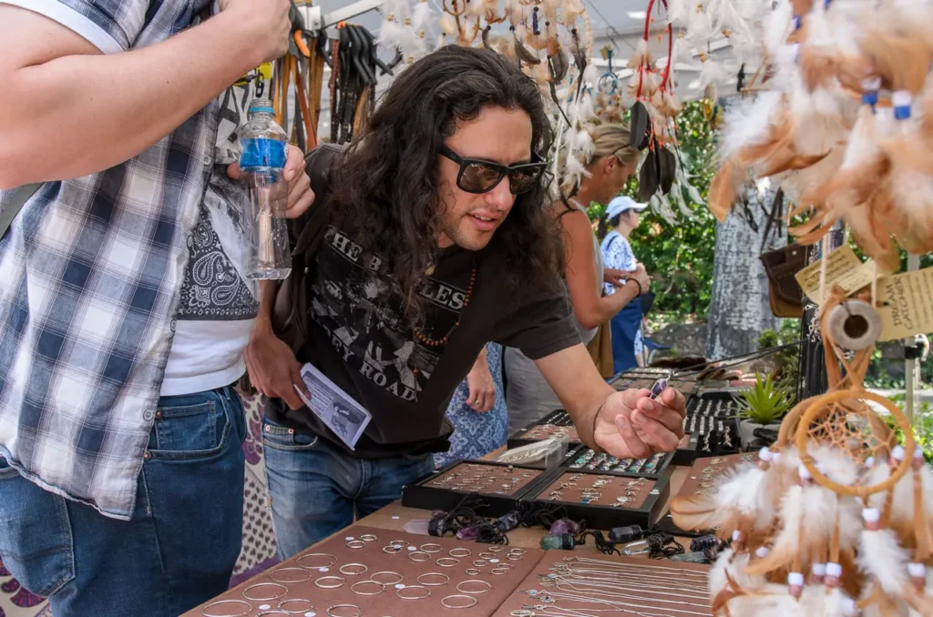Visitor browsing handmade jewellery and dreamcatchers at a creative market stall during Glebe Street Fair