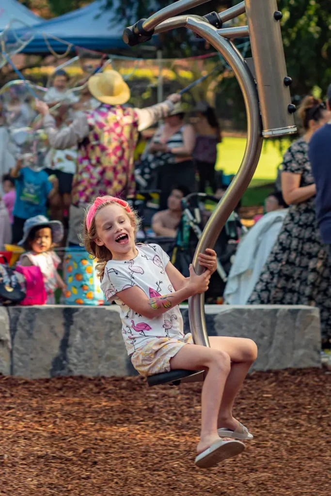 Event photography capturing a child having fun on the playground at the St Leonards Park opening