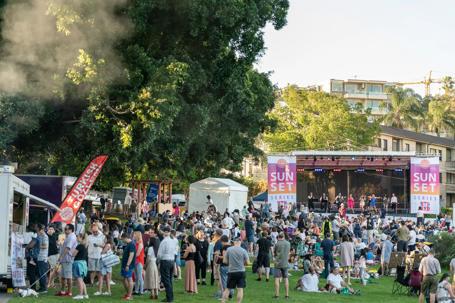 Wide view of the Sunset Series stage, live band and festival crowd at Waverton Park in North Sydney