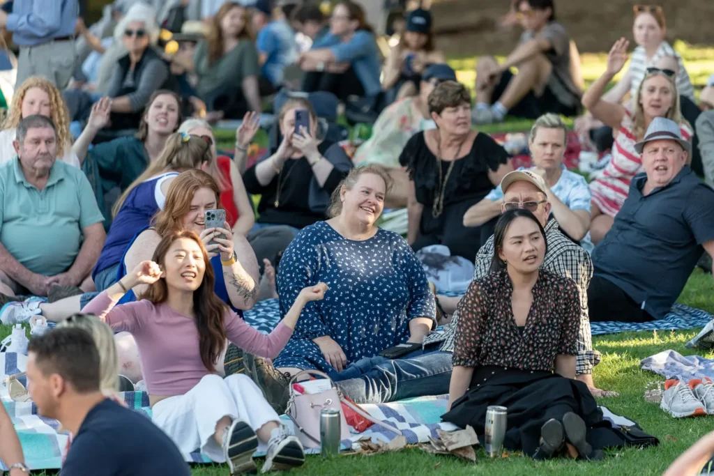 Enthusiastic crowd enjoying live music and singing along at Sunset Series in Waverton Park